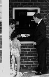 Man showing kids how to use an ATM machine