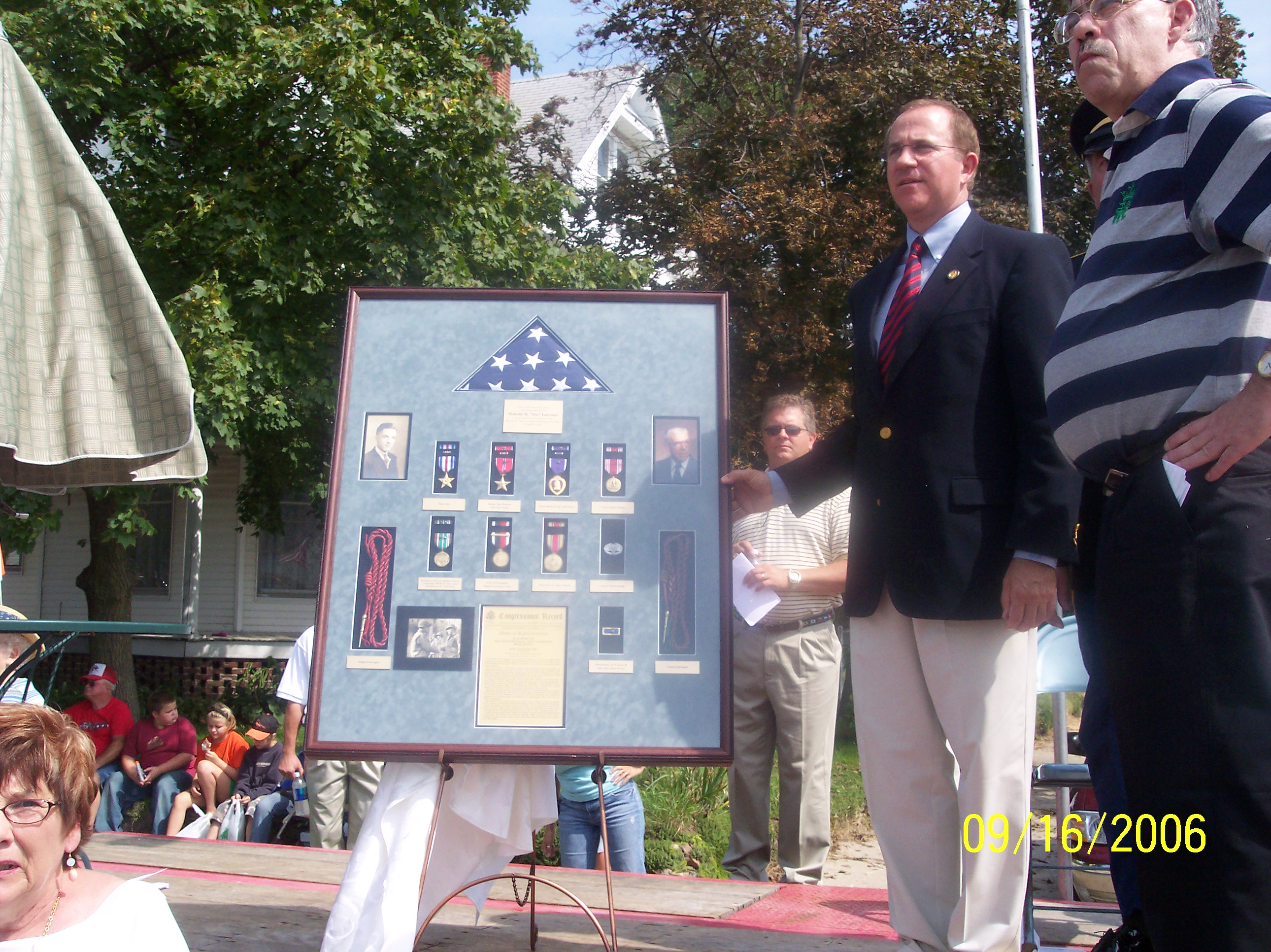 Congressman Buyer and  Jack Lawrence showing  the awards and medals of Mac Lawrence