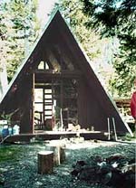 An A-frame cabin photo shows the ladder to the loft through the door open onto the front porch.