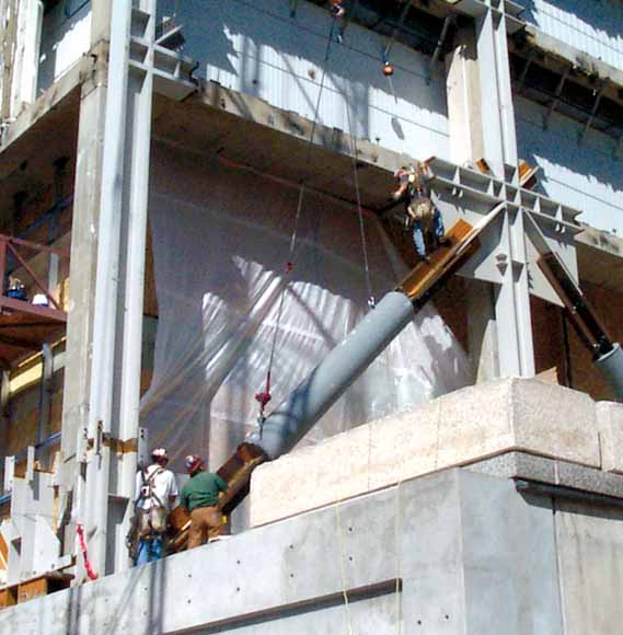 photo of 20-foot dampers fitted diagonally across square section of building.  The dampers look like giant screen-door springs