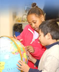 Young students looking at a world globe