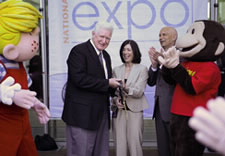 (Posing left to right): Dennis the Menace, Congressman Jim Moran, Debbie Cohn, John Doll and Curious George officially open the 2009 National Trademark Expo. Click for larger image.