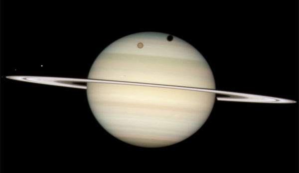 Hubble Space Telescope captured this image of Saturn's moons making a rare transit.