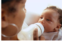 (photograph of a woman feeding a baby)