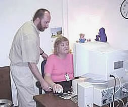 Occupational Therapist adjusting an adaptive armrest on a work site evaluation.