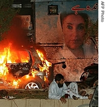 Wounded Pakistani men wait for help on the site of a blast site near the convoy of former prime minister Benazir Bhutto in Karachi, 18 Oct 2007