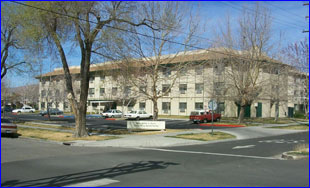 [Photo 1: Three story building with trees in front]