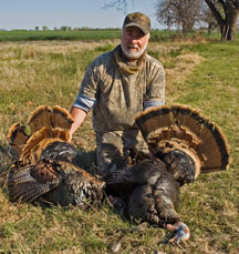 Photograph: Don DeLorenzo posing with wild turkeys from his hunt.