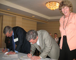 Photograph:  Hank Kashdan and Doug Howell sign the new MOU between Quail Unlimited and Forest Service.  Gail Tunberg assists.