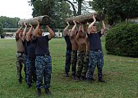  Sailors from Tactical Air Control Squadron (TACRON) 21 carry logs during conditioning training