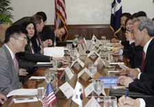 Locke and Kim at conference table with aides. Click for larger image.