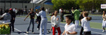 Click to enlarge a photo of DEUCE participants put the program to work by getting limber (or stretching) on the tennis court