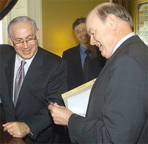 Treasury Secretary John Snow shows Israel's Finance Minister Benjamin Netanyahu, silverware used by The Frist Secretary of Treasury Alexander Hamilton.