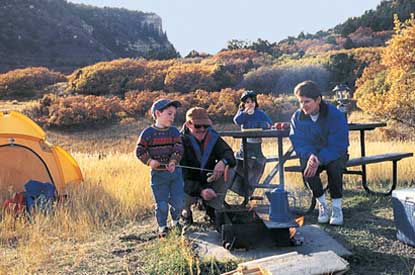 Family cooking over campfire at Morefield Campground