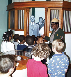 A ranger leads a group of schoolchildren through the bank exhibit at Maggie L. Walker National Historic Site.