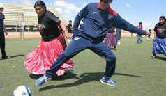 Photo of Jay Miller participating in a scrimmage with Cholitas- female athletes in traditional Bolivian dress