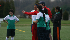 Photo of team members listening to advice from Dan Driscoll, from City FC.