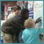 Photo of a teenager pointing at a map with a young child