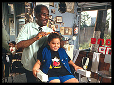 Barber giving a haircut to a young child