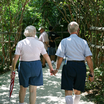 image of two seniors walking on a garden path