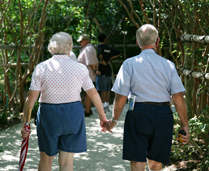 image of two seniors walking on a garden path