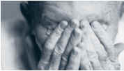 Photo of elderly person with hands over face