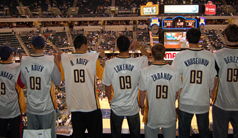 Photo of seven teammates watching the Wizards game from box seats.