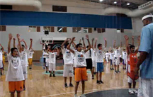Photo of Jerome Williams conducting a basketball clinic with Bahraini students