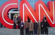 Photo of participants standing in front of a large CNN logo.