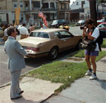 Cooper photographing a man standing on the sidewalk