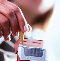 Image of a hand taking a cigarette out of a pack of cigarettes.