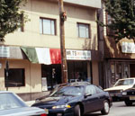Cars in front of a building with an Italian flag hanging on the front