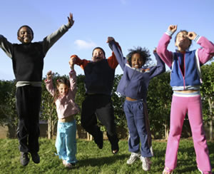 Children outside jumping into the air.