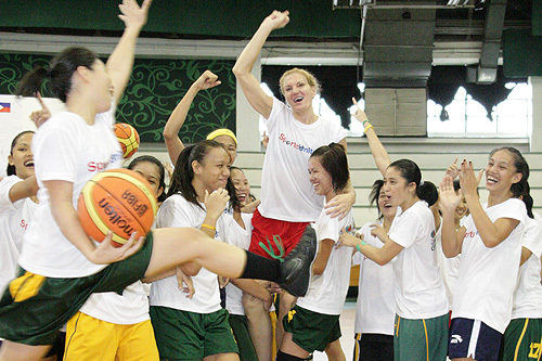 Photo of members of the girls’ team carrying their coach Sue Wicks after a victory against the boys’ team at a basketball clinic in Manila’s San Juan City