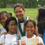 Photo of Tiffany Roberts with boys and girls from a soccer clinic after receiving their certificate of participation in Iloilo, Philippines