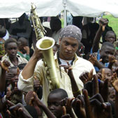 Photo of musician Devin Phillips surrounded by children in the Republic of the Congo