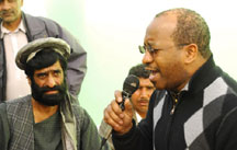 Photo of Alvin Atkinson singing into a microphone in front of a crowd on the streets of Afghanistan