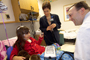 a photo of a child in a hospital bed talking to a doctor.