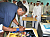 Photo of Sam signing posters for the Qatari students