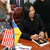 Michelle Kwan signs photos for students in Ukraine.