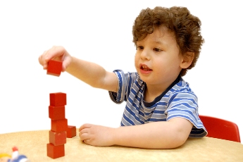 Photo: Child playing with blocks at table