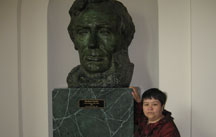 Photo of Uzbek Award Winner Mutabar Tadjibayeva standing next to figure of President Lincoln
