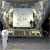 In this image, against the dark backdrop of the Florida night, the 'mouth'  of a large Air Force cargo plane is open, revealing one of two large white boxes containing the Mars Reconnaissance Orbiter.  The box is more than two times the height of the men standing in front of it, supervising its move off of the aircraft.