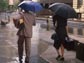 People holding umbrellas in rainy weather.