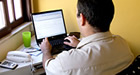 Photo: A man typing on a laptop computer