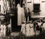 A woman on a balcony unfurling a banner.