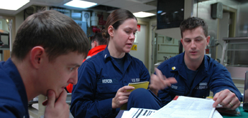 Coast Guardmen discuss plans for conducting at sea boardings of fishing vessels taking part in the Kodiak Tanner Crab fishery.