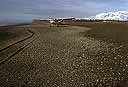 Sand and gravel beach with small plane on the ground