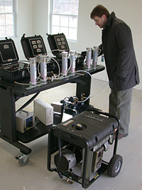 NIST is working with the Consumer Product Safety Commission (CPSC) to 
				quantify the dangers of improperly used gasoline-powered portable generators 
				and to evaluate possible technical solutions to the problem. Here, NIST researcher 
				Steven Emmerich adjusts a multi-gas analyzer that will measure carbon monoxide, 
				oxygen, carbon dioxide and hydrocarbons concentrations produced by such a generator located, 
				against safety advice, in a garage.