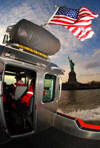 Coast Guard crew from Station New York on Staten Island patrol the waters surrounding the Statue of Liberty in New York Harbor at dusk during a ports, waterways and coastal security patrol.